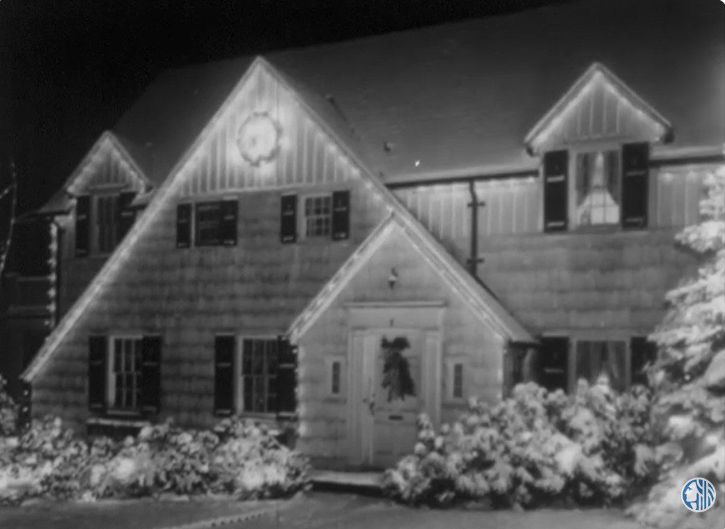 black and white photo of a house decorated with holiday lights