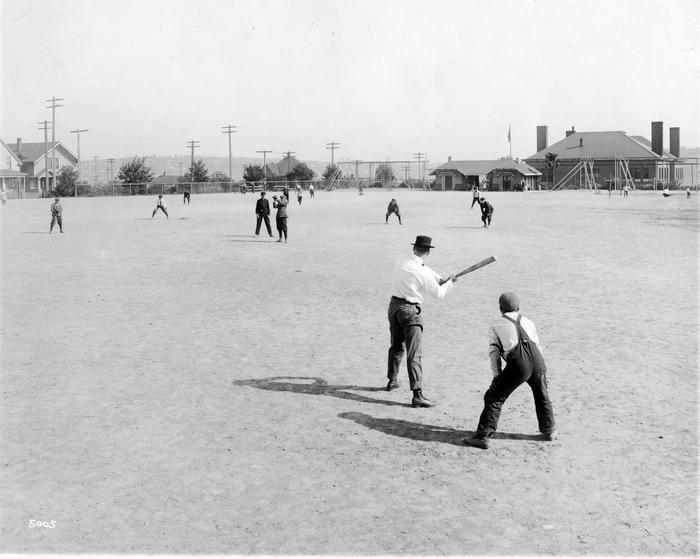 men playing baseball in a field around 1916
