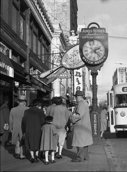 pedestrians under street clock in downtown Seattle
