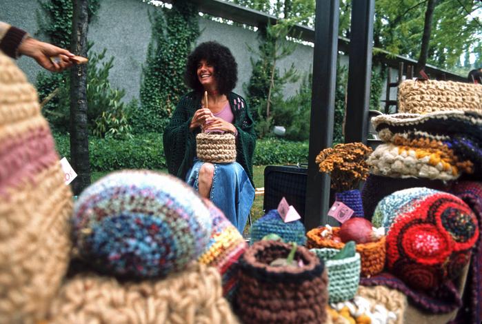 smiling woman selling baskets with her wares in the foreground