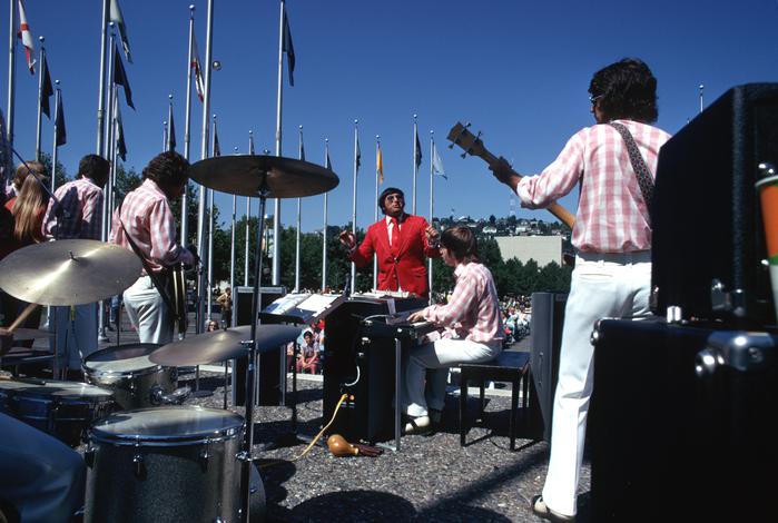band playing outside under flags